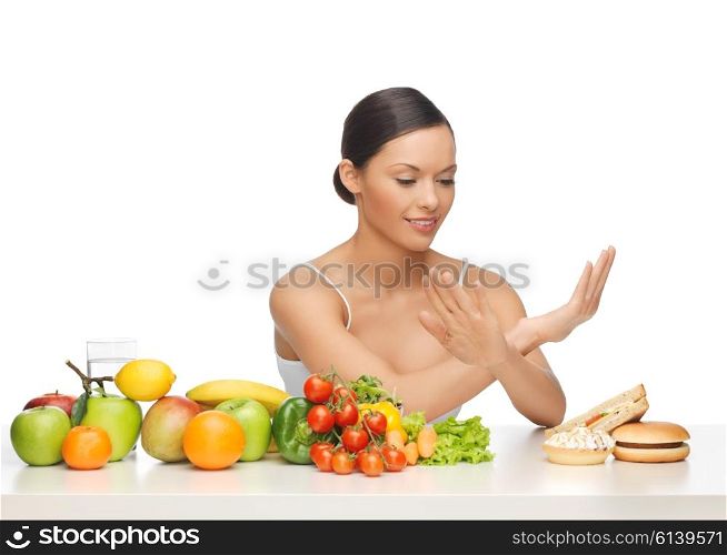picture of woman with fruits rejecting hamburger. woman with fruits rejecting hamburger