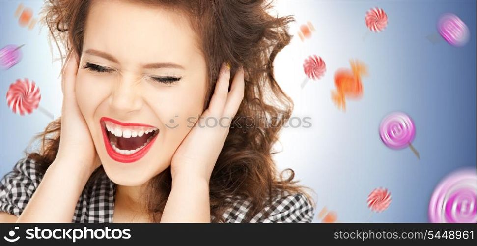 picture of woman with hands on ears and flying lollipops