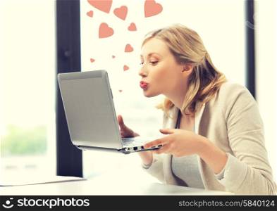 picture of woman with laptop computer sending kisses and hearts. woman with computer kissing the screen