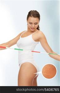 picture of woman with measuring tape looking at her cellulite