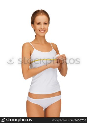 picture of young beautiful woman measuring her breast