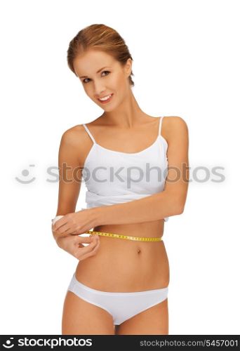 picture of young beautiful woman measuring her waist