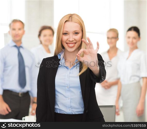 picture of young businesswoman showing ok sign in office
