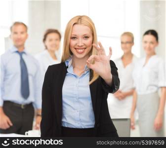 picture of young businesswoman showing ok sign in office