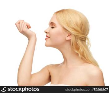 picture of young girl smelling pefrume on her hand