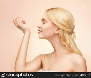 picture of young girl smelling perfume on her hand