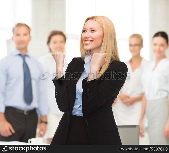 picture of young happy woman with hands up in office