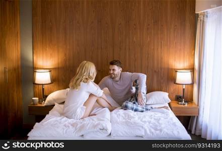 Picture of young loving couple enjoy while sitting in the bed