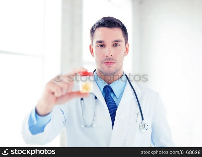 picture of young male doctor with jar of capsules. male doctor with jar of capsules