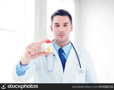 picture of young male doctor with jar of capsules. male doctor with jar of capsules