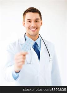 picture of young male doctor with pack of pills