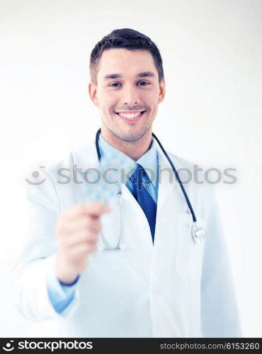 picture of young male doctor with pack of pills. young male doctor with pack of pills