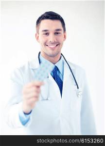 picture of young male doctor with pack of pills. young male doctor with pack of pills