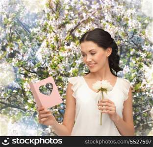 picture of young woman holding flower and postcard