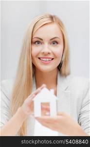 picture of young woman holding white paper house