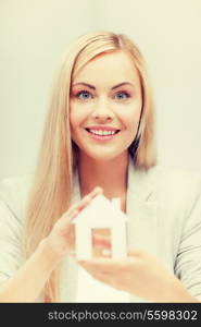 picture of young woman holding white paper house