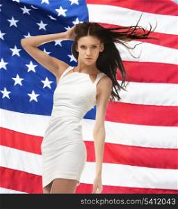 picture of young woman posing in white dress over american flag