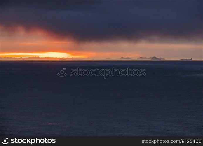 Picturesque autumn evening view above Atlantic ocean from Dyrholaey Cape, Vik, South Iceland. Vestmannaeyjar islands weird silhouettes on horizont.