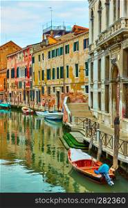 Picturesque canal with moored boats in Venice, Italy