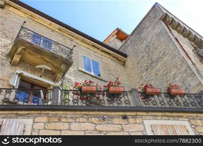 Picturesque house with flowers on balcony in the Italian city
