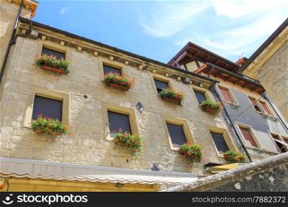Picturesque house with flowers on windows in the Italian city