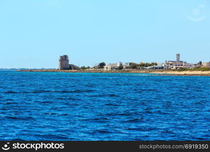 Picturesque Ionian sea Torre Colimena beach, Salento, Puglia, Italy. Historical fortification tower Torre Colimena in far.