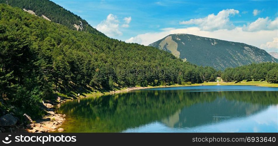 Picturesque lake, mountains and blue sky. Wide photo
