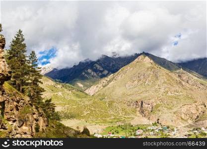 Picturesque landscape with a small village at the foot of mountains