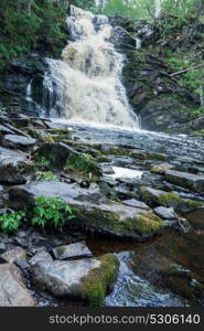 Picturesque landscape with a waterfall in the forest of Karelia, Russia