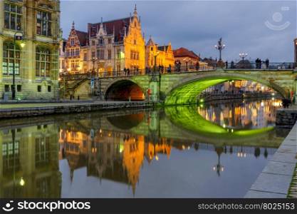 Picturesque medieval building and St. Michael&amp;#39;s Bridge with an unusual green illumination in the evening in Ghent, Belgium