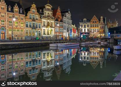 Picturesque medieval building on the quay Korenlei with reflections in Ghent town at night, Belgium