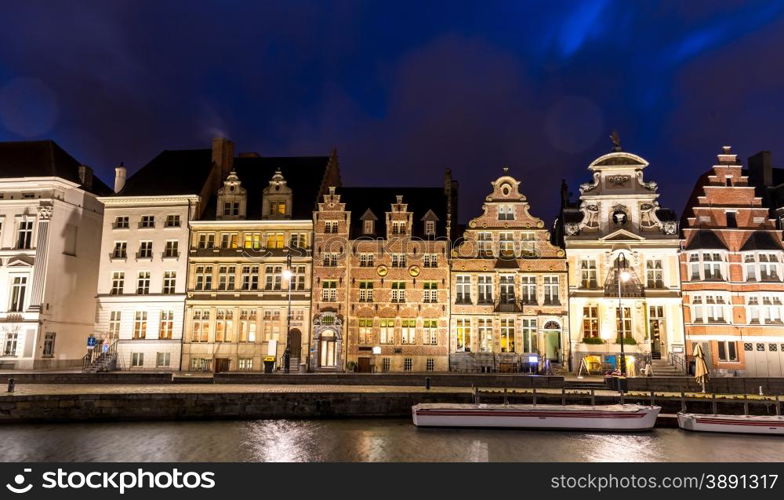 Picturesque medieval buildings on Leie river in Ghent town, Belgium at dusk.