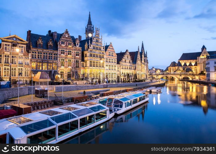 Picturesque medieval buildings on Leie river in Ghent town, Belgium at dusk.