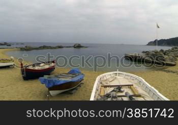 Picturesque Mediterranean fishing boats in la Costa Brava, Girona.Aerial drone shot flying over the barques near the seaside.Typical Mediterranean landscape wooden boats and pristine beaches.