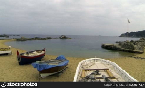 Picturesque Mediterranean fishing boats in la Costa Brava, Girona.Aerial drone shot flying over the barques near the seaside.Typical Mediterranean landscape wooden boats and pristine beaches.