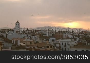 Picturesque Mediterranean fishing village in la Costa Brava, Girona.Typical Mediterranean landscape with white houses and tile roofs.Sun golden light over the bell tower early in the morning.First sunlight over the belfry in summer.