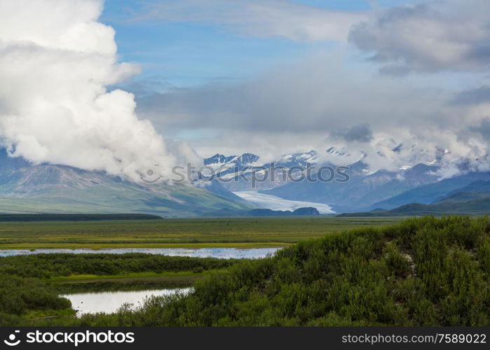 Picturesque Mountains of Alaska in summer. Snow covered massifs, glaciers and rocky peaks.