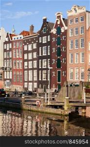 Picturesque old houses by the canal in the city of Amsterdam, Holland, Netherlands.