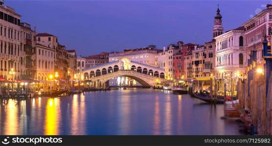 Picturesque panoramic view of famous Rialto Bridge over the Grand Canal in Venice at night, Italy.. The Rialto Bridge, Venice, Italy