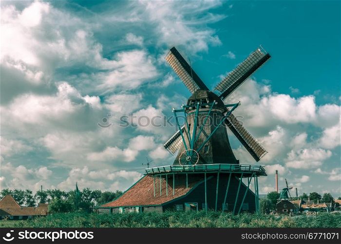 Picturesque rural landscape with windmills in Zaanse Schans close to river, Holland, Netherlands. Toning in cool tones