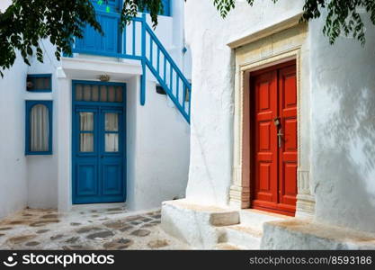 Picturesque scenic narrow Greek streets with traditional whitewashed houses with blue doors windows of Mykonos town in famous tourist attraction Mykonos island, Greece. Greek Mykonos street on Mykonos island, Greece