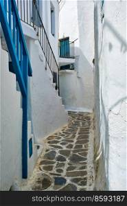 Picturesque scenic narrow Greek streets with traditional whitewashed houses with blue doors windows of Mykonos town in famous tourist attraction Mykonos island, Greece. Greek Mykonos street on Mykonos island, Greece