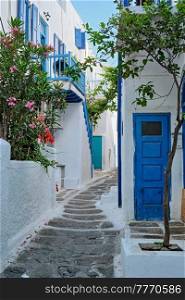 Picturesque scenic narrow streets with traditional whitewashed houses with blue doors windows of Mykonos Chora town in famous tourist attraction Mykonos island, Greece. Mykonos Chora town street on Mykonos island, Greece