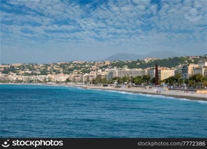 Picturesque scenic view of Mediterranean sea coast in Nice, France. Mediterranean Sea waves surging on the coast, people are relaxing on the beach. Nice, France. Picturesque view of Nice, France