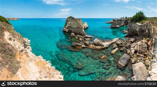 Picturesque seascape with cliffs, rocky arch and stacks (faraglioni), at Torre Sant Andrea, Salento sea coast, Puglia, Italy. People unrecognizable.