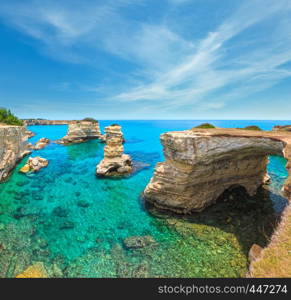 Picturesque seascape with cliffs, rocky arch and stacks (faraglioni), at Torre Sant Andrea, Salento sea coast, Puglia, Italy