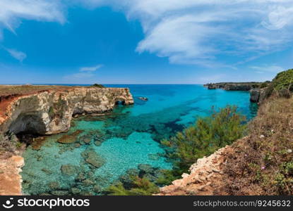 Picturesque seascape with cliffs, rocky arch and stacks (faraglioni), at Torre Sant Andrea, Salento sea coast, Puglia, Italy