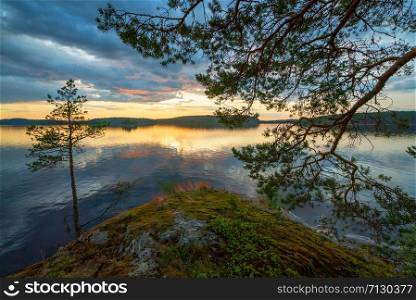 Picturesque stone shore of the island on the lake . Ladoga Skerries, Karelia.. Sunset on the edge of the shore of the island on lake Ladoga .