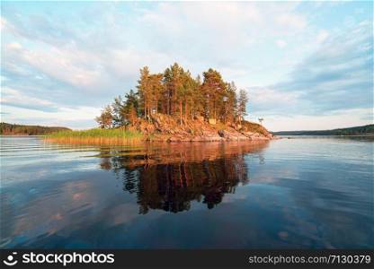 Picturesque stone shore of the island on the lake . Ladoga Skerries, Karelia.. Picturesque coastline of the island with a reflection on lake Ladoga .