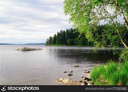 Picturesque stone shore of the island on the lake . Ladoga Skerries, Karelia.. On the shore of lake Ladoga with a small stone island .